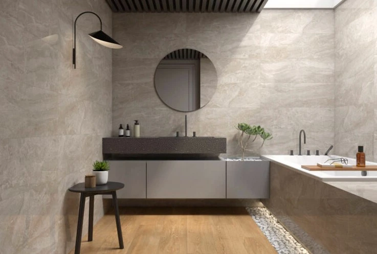 Reforma de baño con revestimiento cerámico efecto piedra, espejo circular y suelo laminado en Alicante