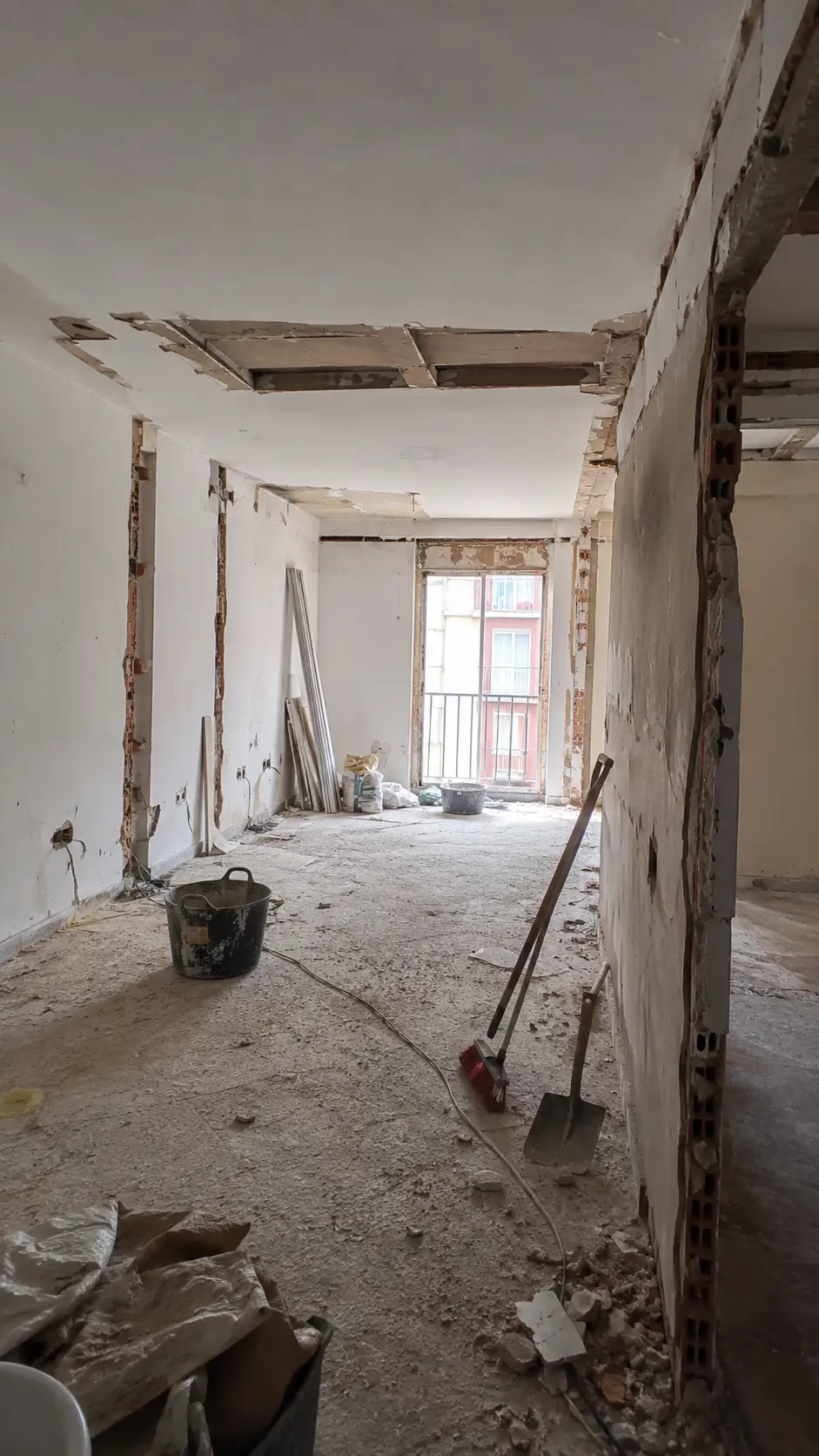 Reforma integral en fase de demolición con tabiques derribados, escombros y herramientas de obra en Alicante